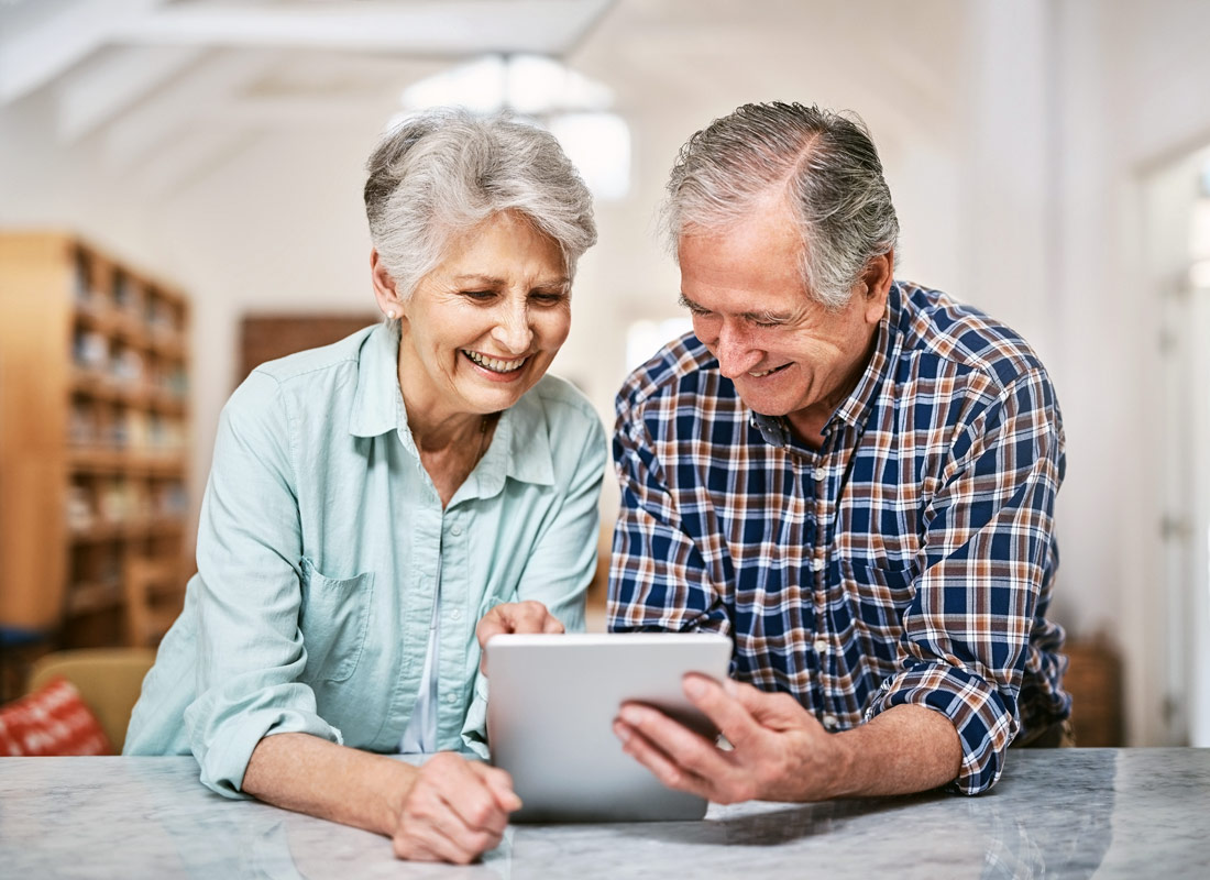 A couple sharing their tablet device whilst they research their family history